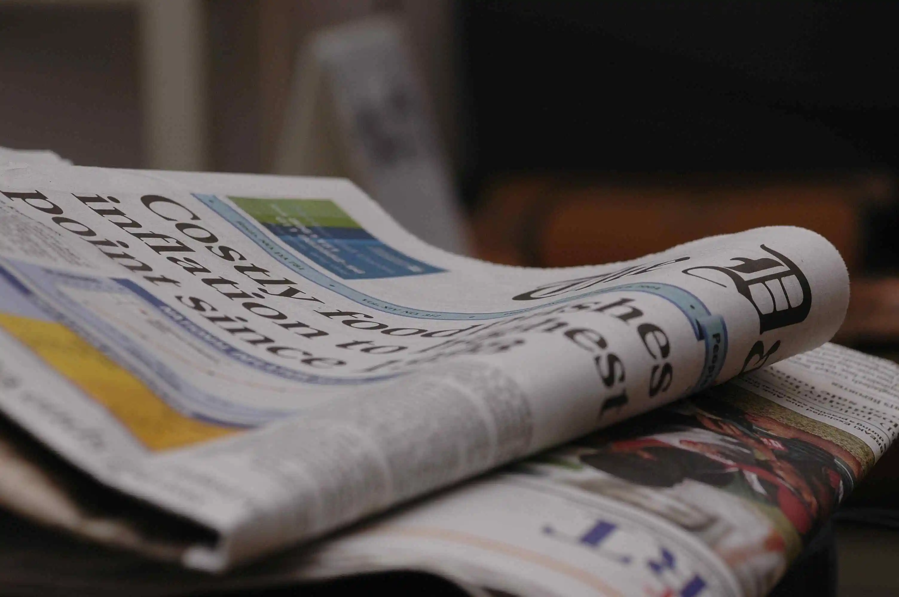 Jornal empresarial dobrado numa mesa com foco na secção de notícias de economia